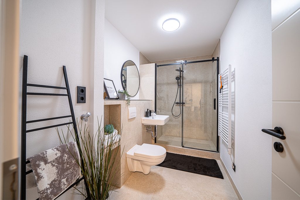 Modernes Duschbad mit bodengleicher Dusche, Waschbecken und Handtuchheizkörper